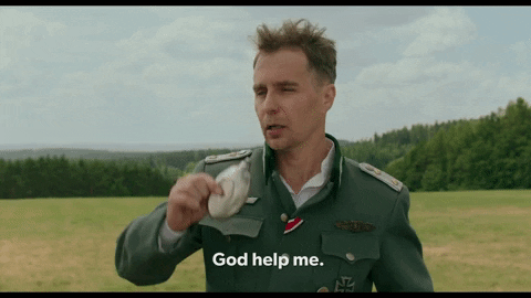 Captain K (Sam Rockwell,) drinking from a flask, wearing a Nazi uniform: God help me.