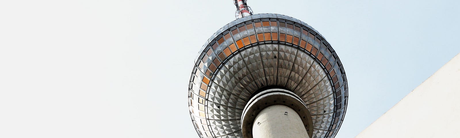 A bottom up picture of a television tower with a large spherical, glass-covered observation deck.