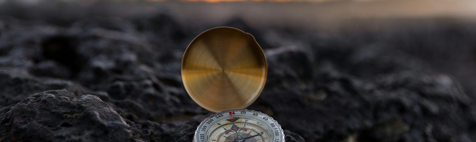 Golden compass on the black stones showing the direction.