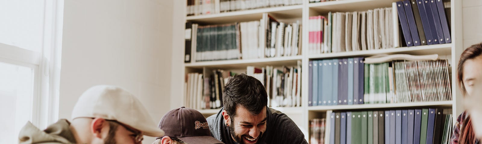 People talking and laughing in front of a computer