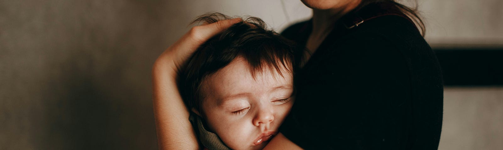 Mother holding her blissfully sleeping child.