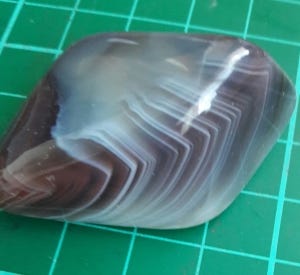 a polished crystal with distinctive chevron markings