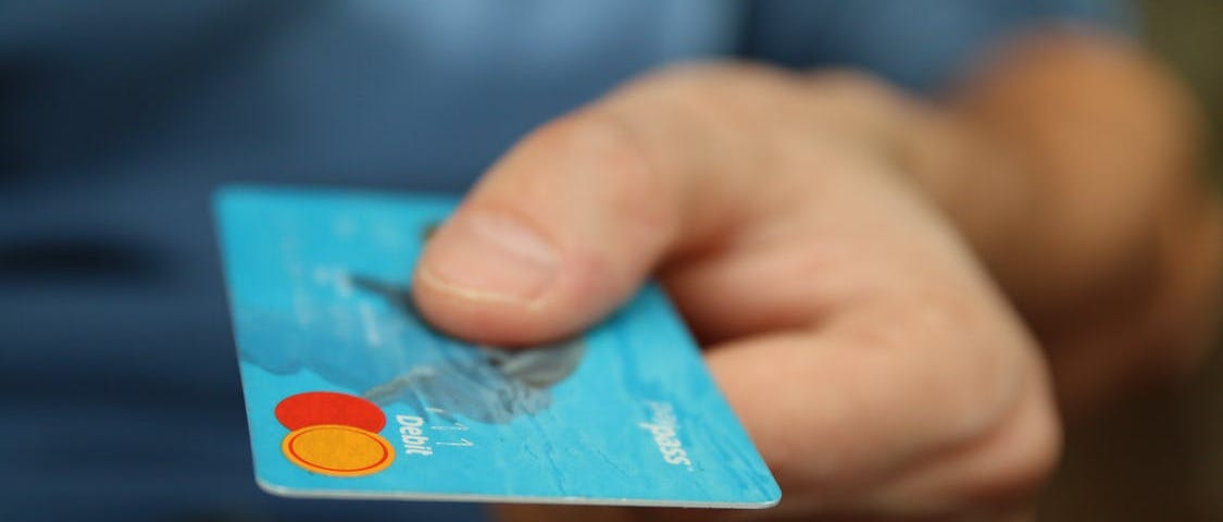 Man handing a credit card to a merchant.