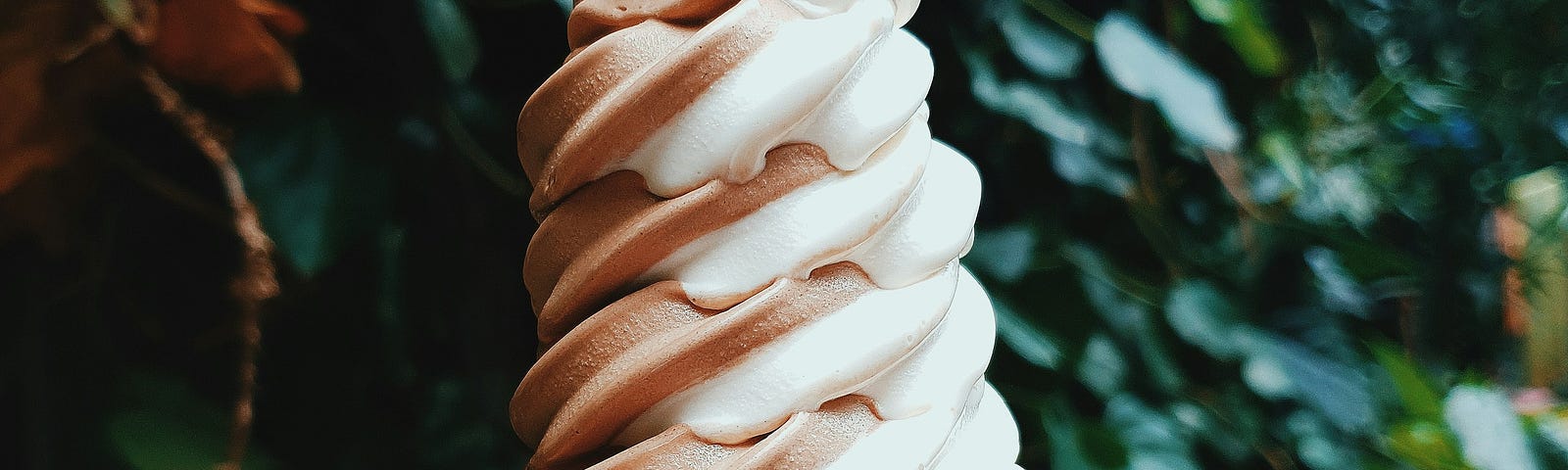 A man holding a chocolate and vanilla swirl soft-serve ice cream cone.