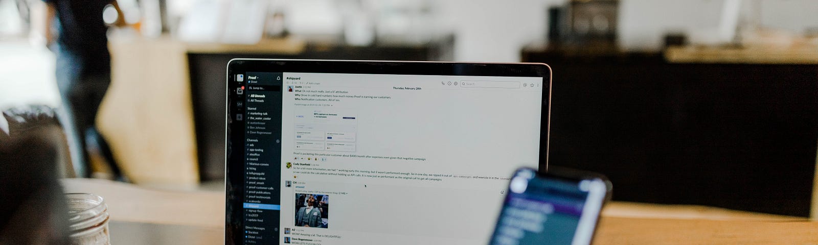 Man typing on phone while on computer