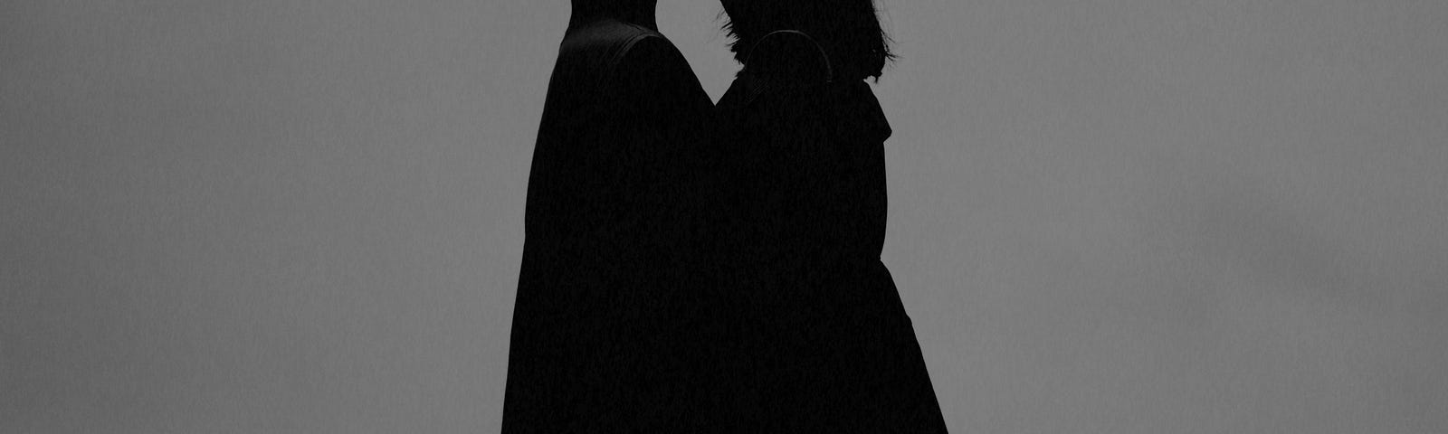 Silhouette of a young couple kissing.