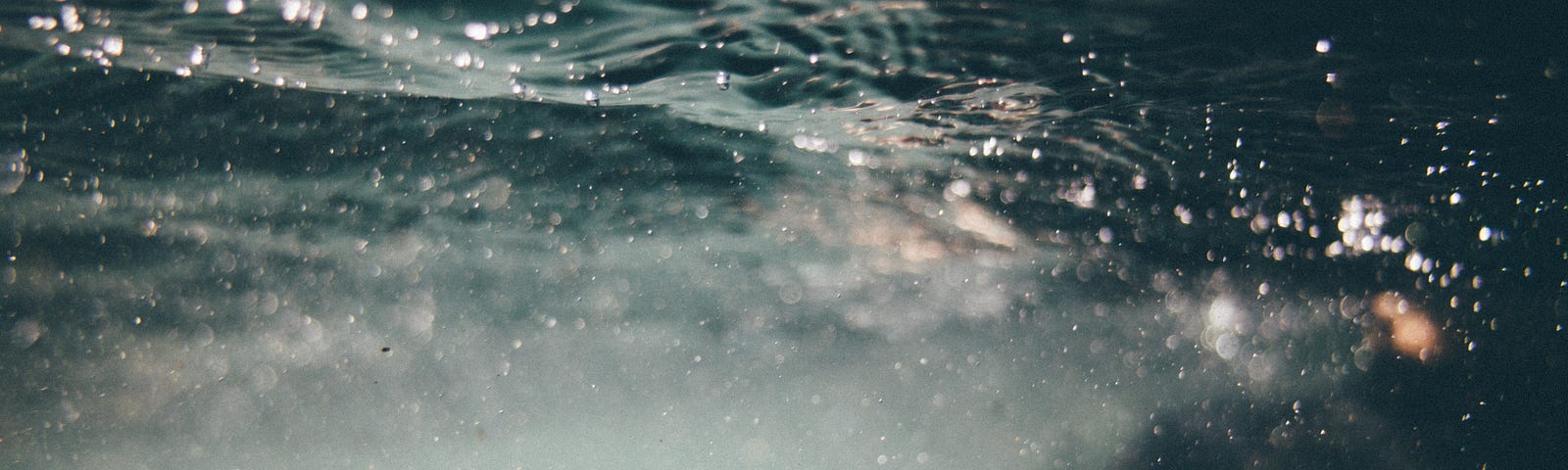 The murky water of a pool, and bodies moving around in darkness.