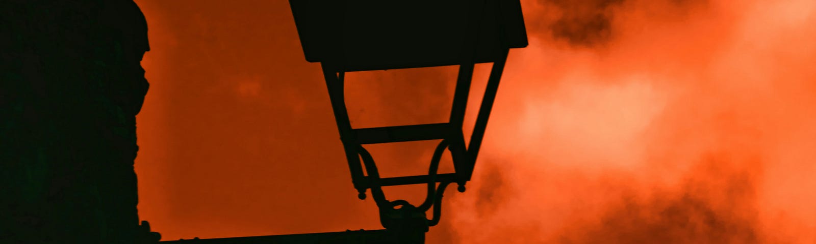 Dark, reddish clouds and fog envelop the scene, where a lantern is visible.