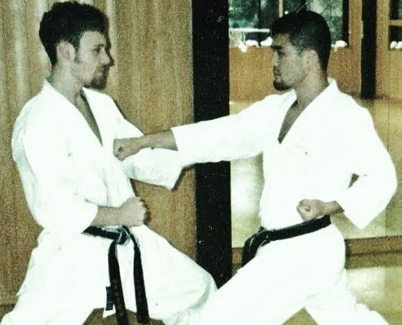 A traditional karateka performs a basic punch against a partner.