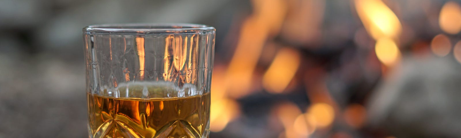 glass of whiskey in front of a fire.