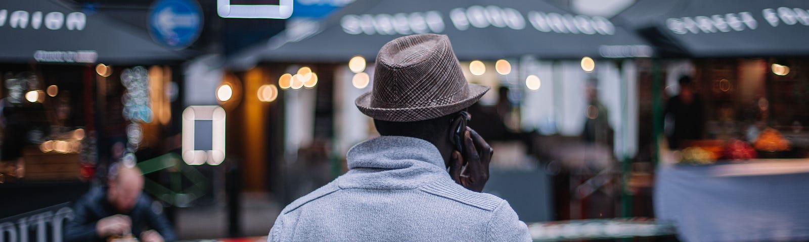 Man in a hat gesturing as he talks on the phone