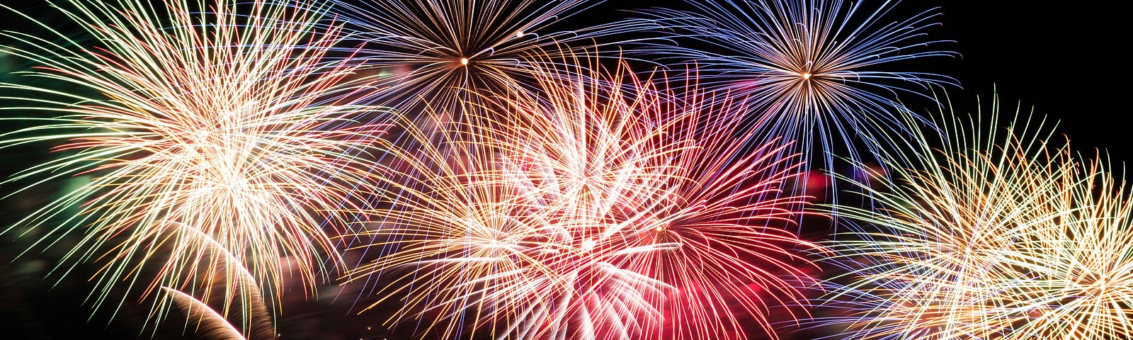 People silhouetted as they watch a firework display