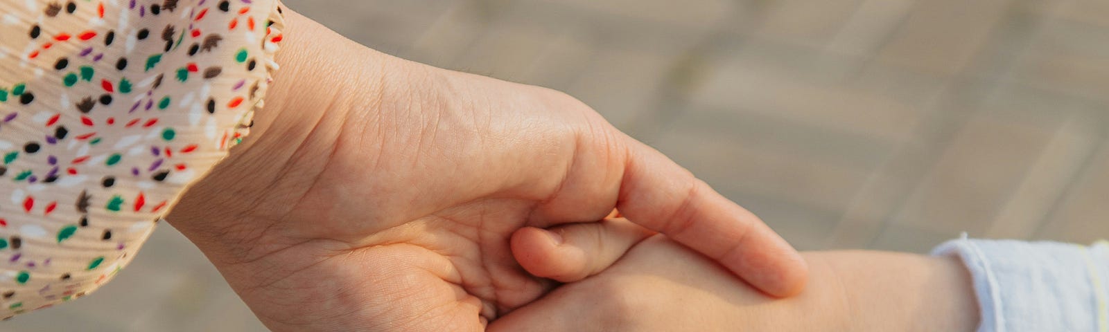a parent holds the hand of a child