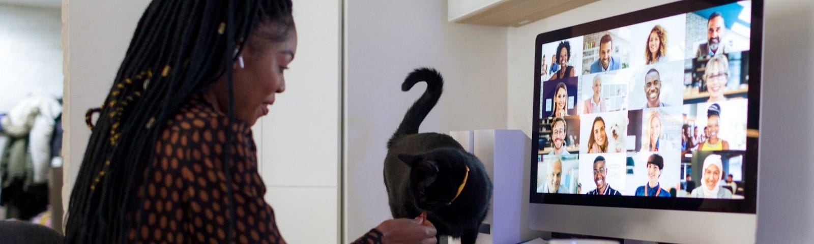 Woman interacts with her cat while on a video meeting. Photo by vgajic/Getty Images