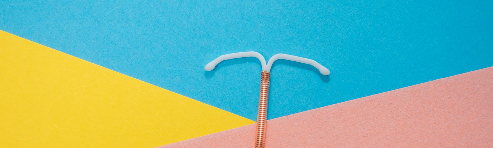 An IUD device on a colorful background