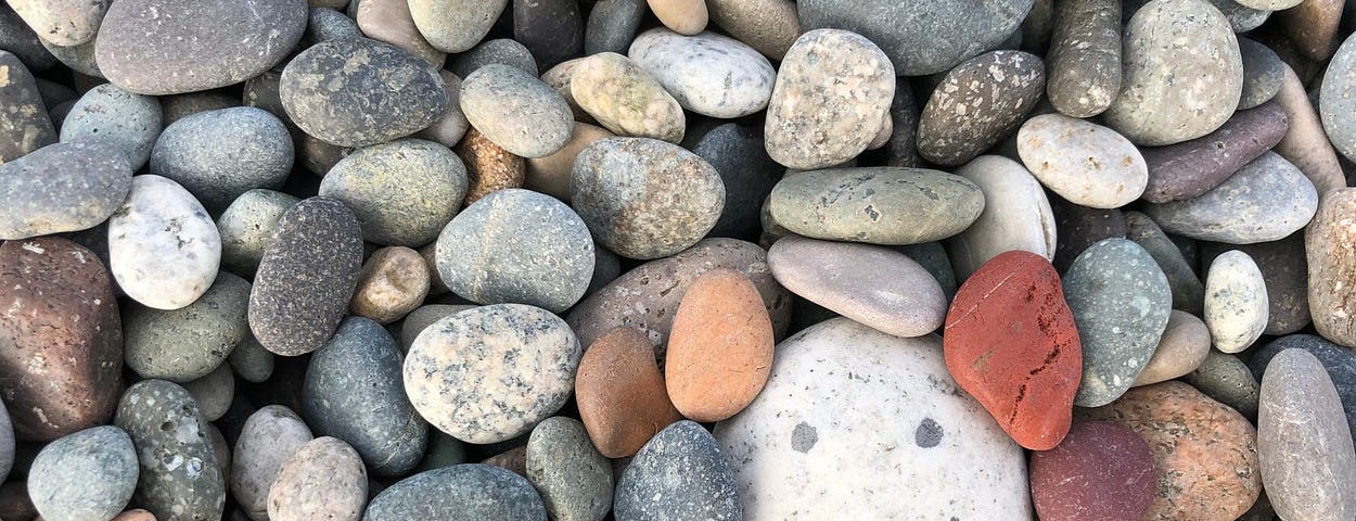 Pebbles in shades of grey with a smilie