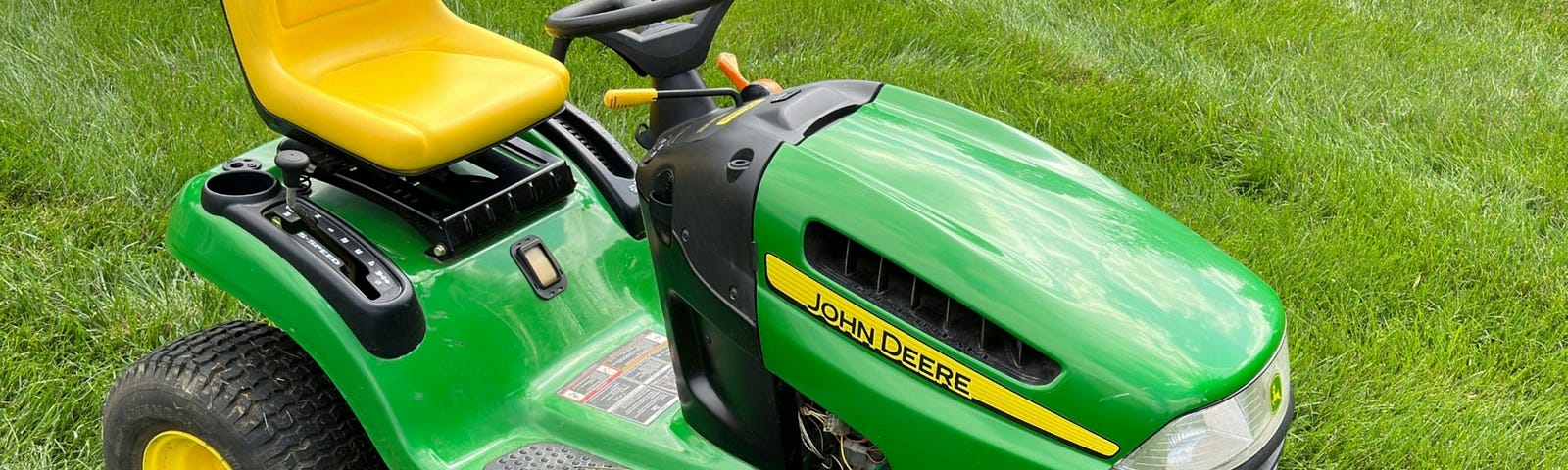 A green riding lawn mower.