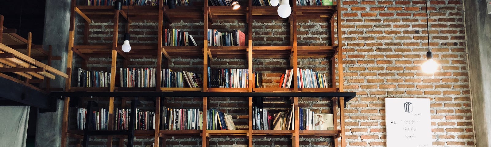 floor to ceiling wood bookshelves against brick wall