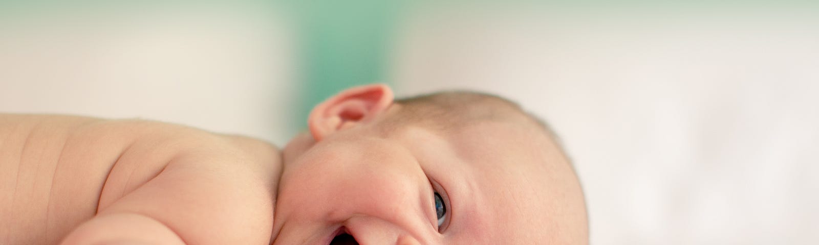 A smiling baby laying on a blanket