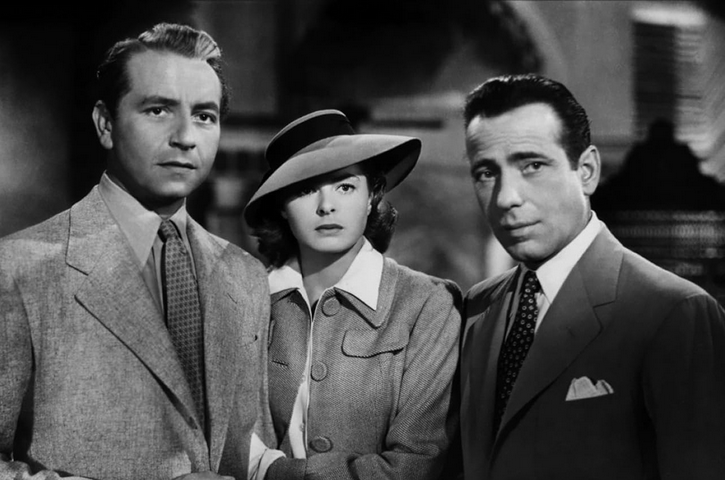 A man, a woman, and another man stand next to each other looking off camera