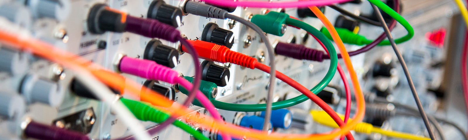 An image of a circuit board with multiple colored wires attaching and plugged in to different places.