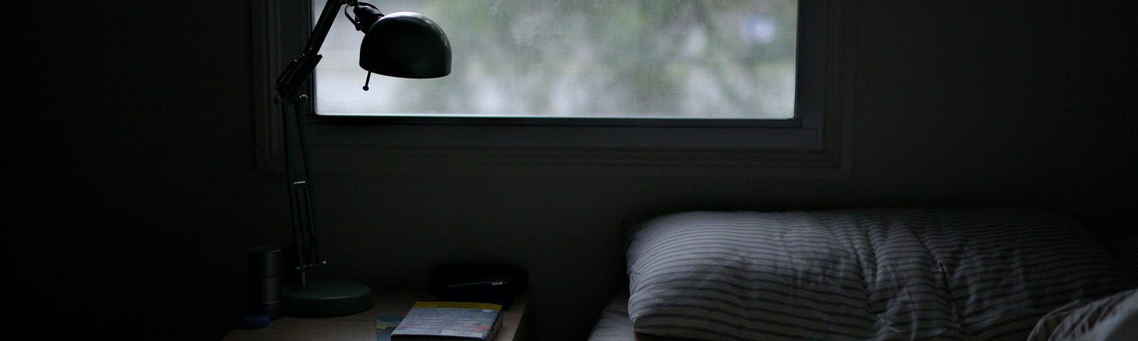 Photo of bed near task lamp