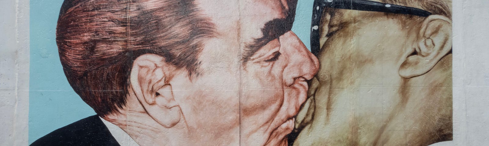 A piece of the Berlin Wall with a graffiti painting showing Brezhnev and Honecker kissing — and a text in German saying: My God, Help Me to Survive This Deadly Love (and a brief version of the same text in Russian). The painting was made in 1900 by Dmitri Vrubel.