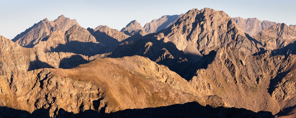 An endless maze of rugged peaks and connecting ridges all bathed in early morning light.