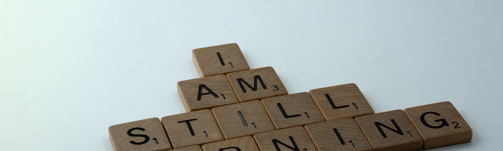 Lettered tiles spelling out, “I am still learning”