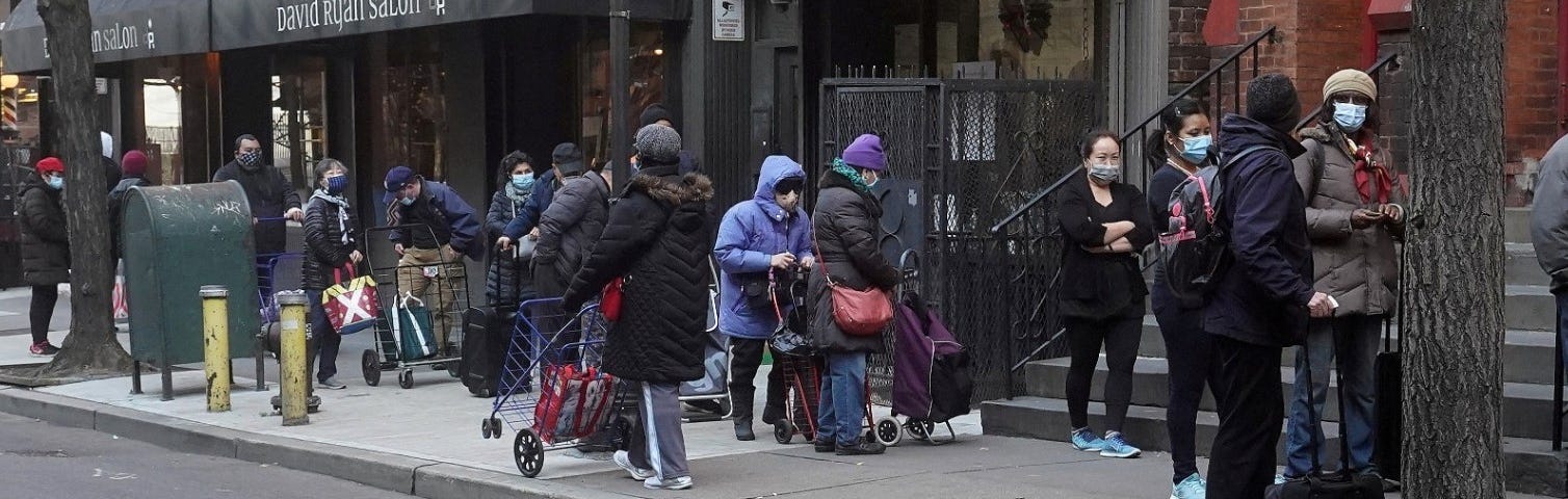 People wait in line at the St. Clements Food Pantry in New York City, December 11, 2020. Photo by Carlo Allegri/Reuters