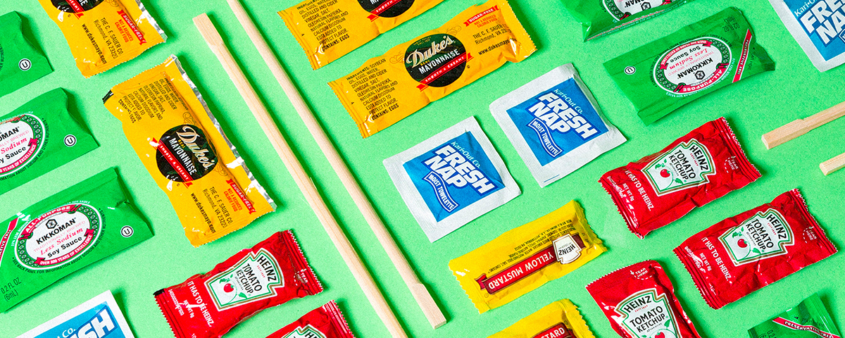 A stylized shot of food delivery freebies: chopsticks, condiment packets, wet wipes