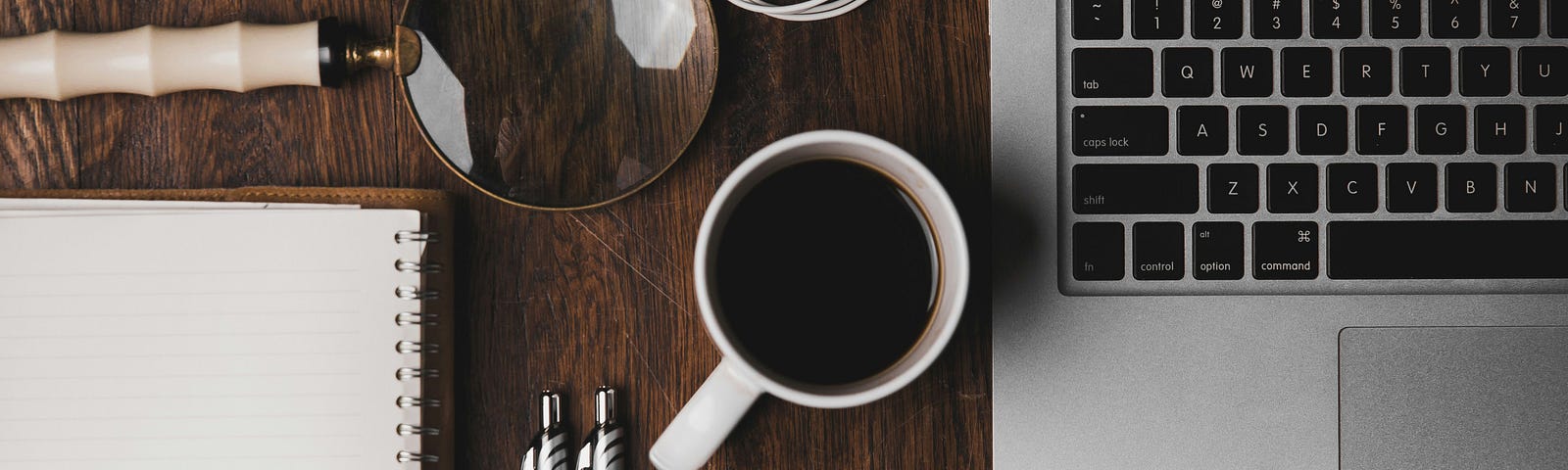 An organized desk containing a coffee mug, a laptop and a notebook along with other small components. It’s used in this article to signify that the topic is mostly work-related.