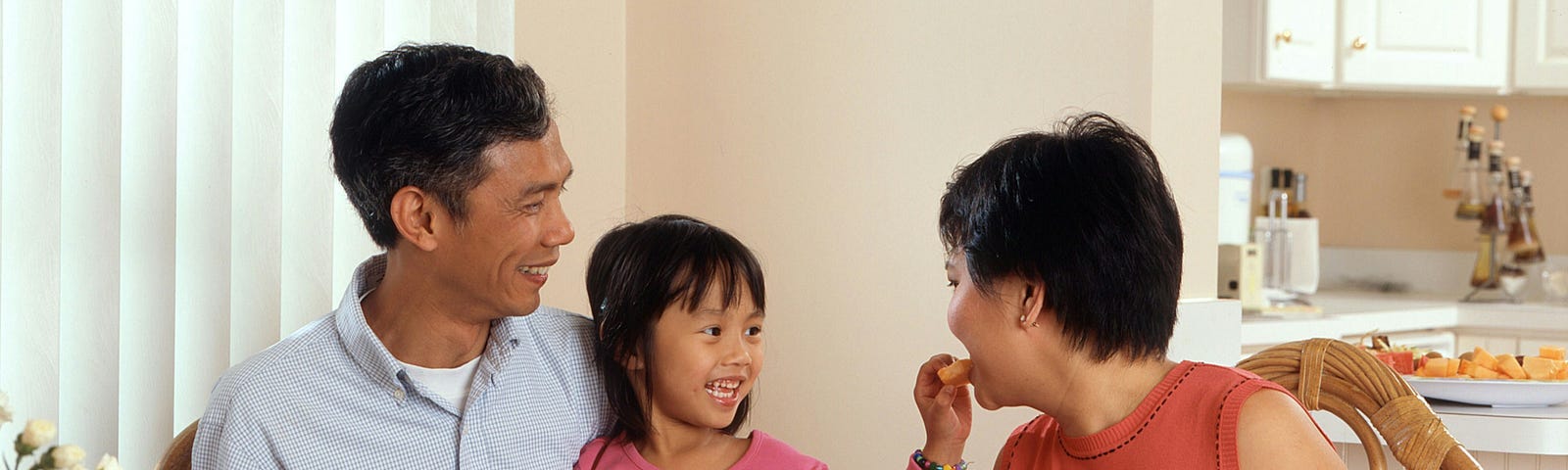 Parents with their daughter at the dining table.