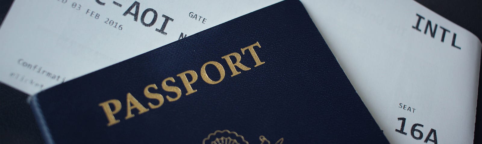 Photo of the cover of a passport and a plane ticket