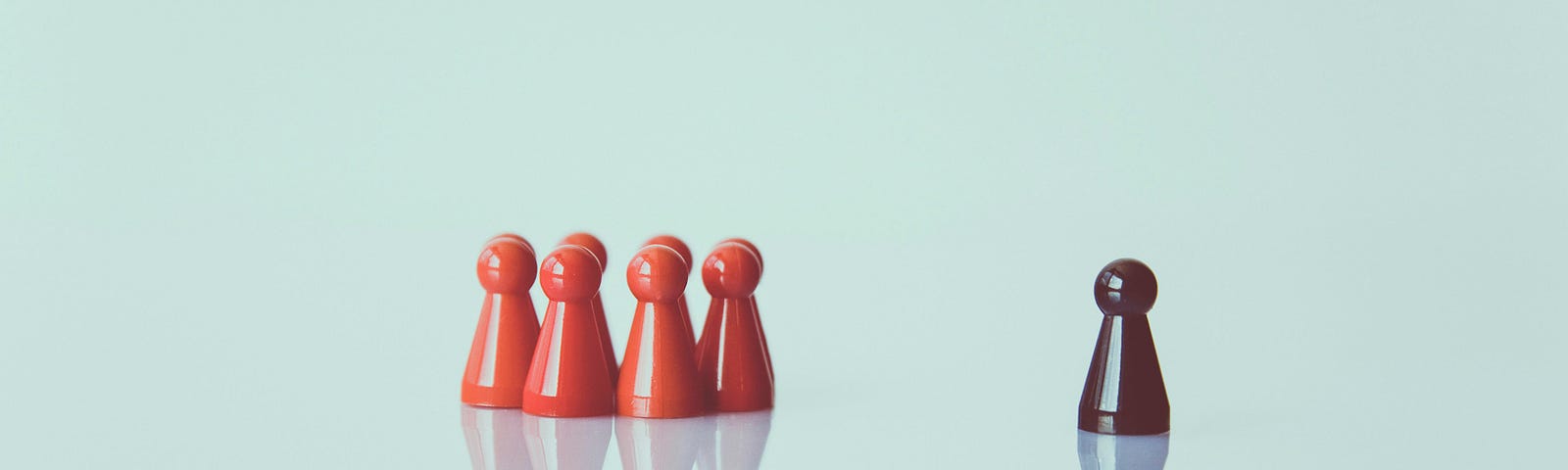 Picture of a group of red pawns together, and a single black pawn set off to the side.