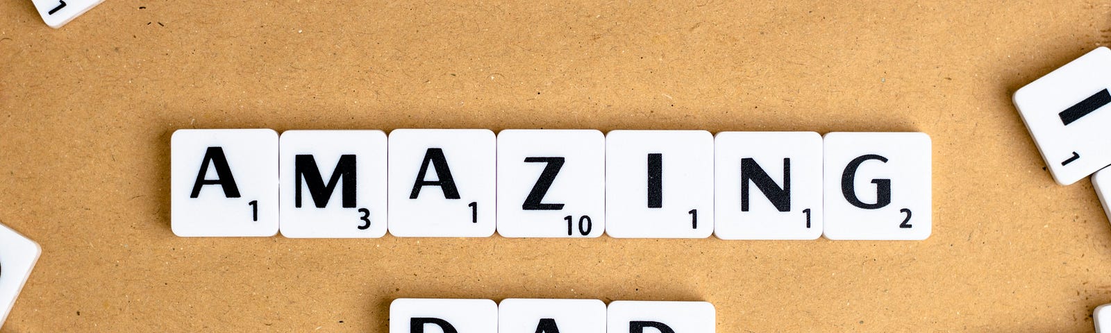Scrabble tiles that spell “amazing dad.”