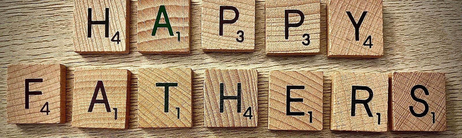 alphabets spell “Happy Fathers Day” on blocks of wood.