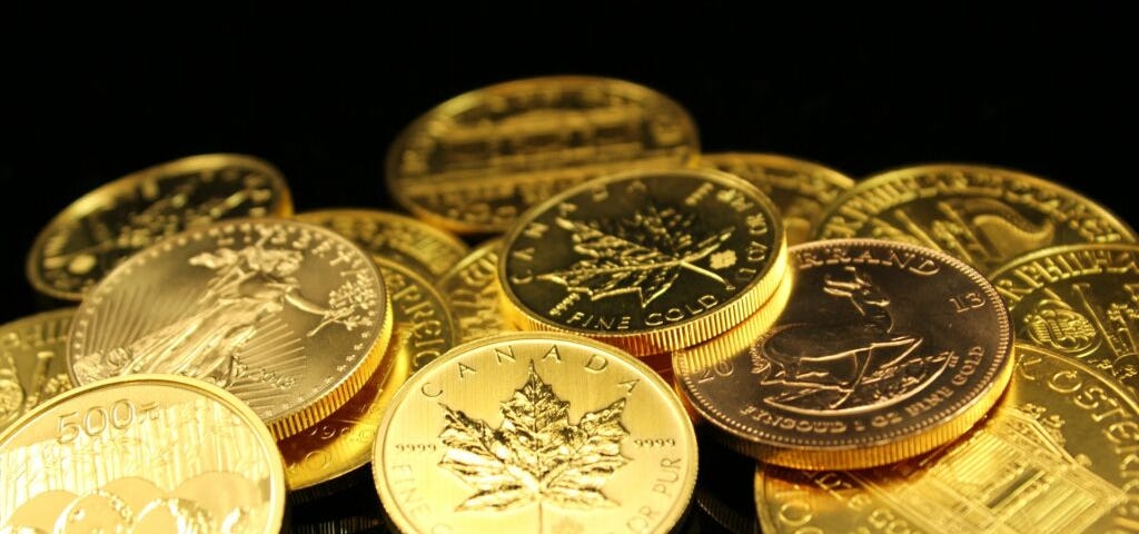 Several gold coins including Canadian Maple Leaf, Krugerand and gold Euros. Image courtesy of Zlat’aky.cz at Pexels.