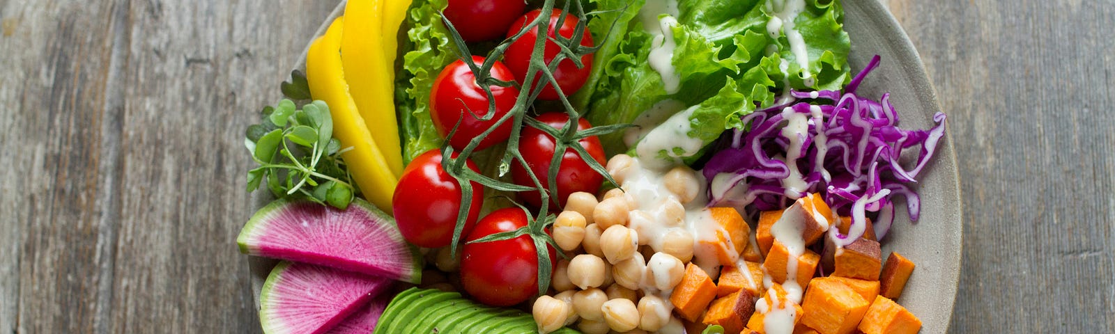 A picture of a beautiful array of many vegetables on a large white plate.