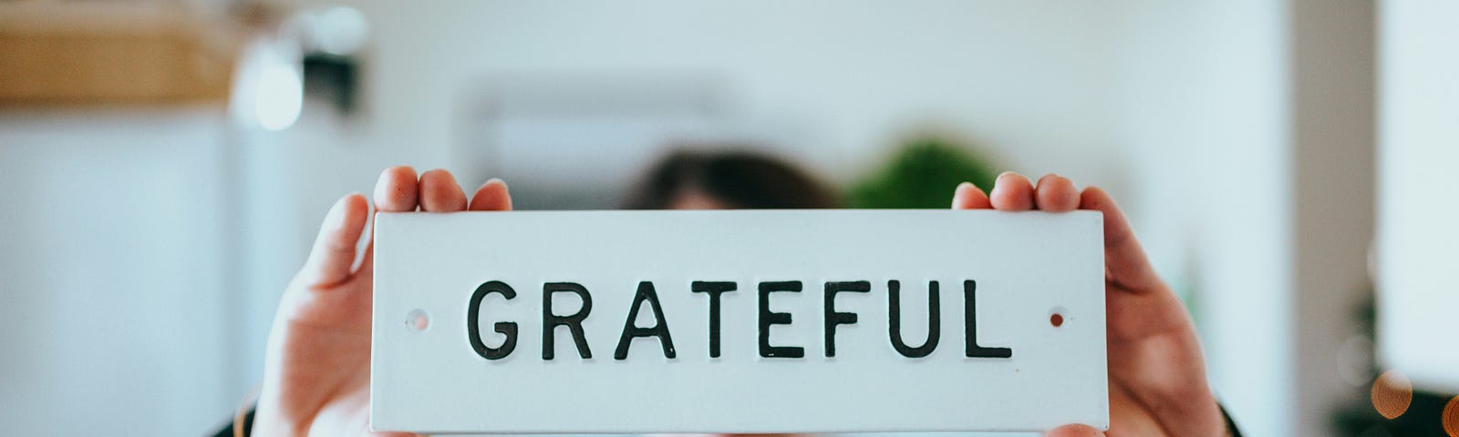 Person holding a sign that reads Grateful