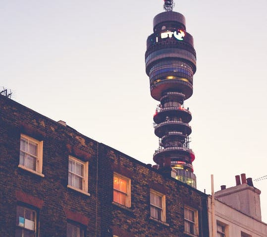 A photo of a block of flats at dusk with the BT tower in the background