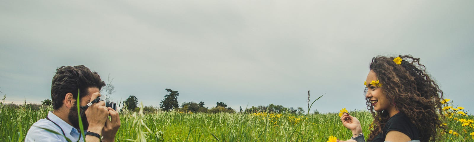 man taking photos of woman in a flowery field