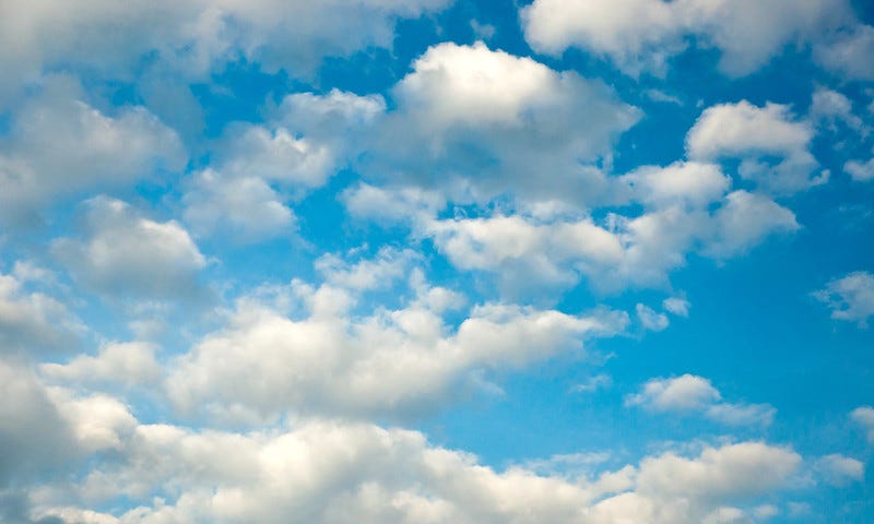 Fluffy white clouds on a blue sky.