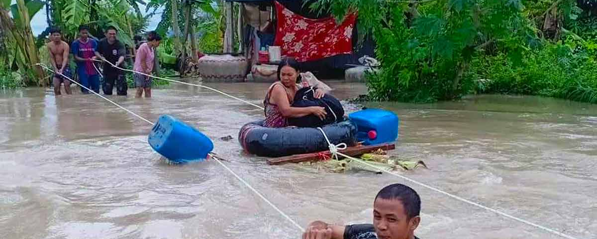 A soldier (front) holds onto a rope as a woman (center) is pulled to safety through flood waters in a village in Cambodia’s western Battambang province, following heavy rains in the region. (AFP Photo)