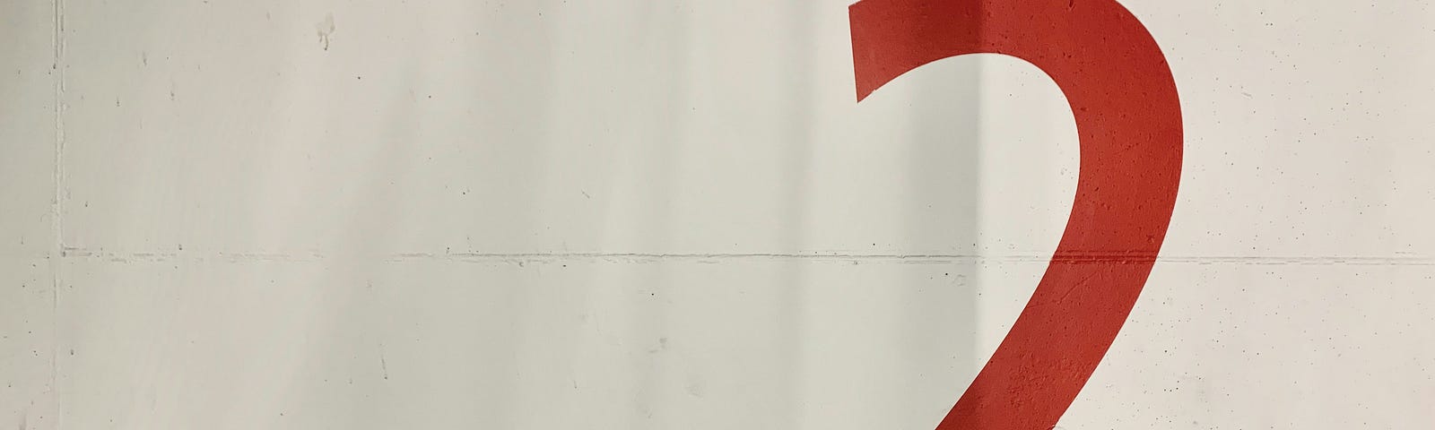 A large, red number two painted on a white wall