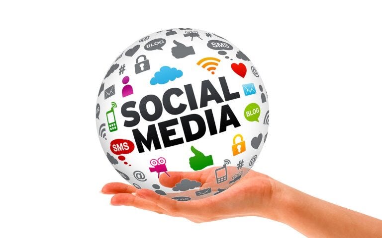 A hand holding a sphere with “SOCIAL MEDIA” and social media-related icons written all over it.