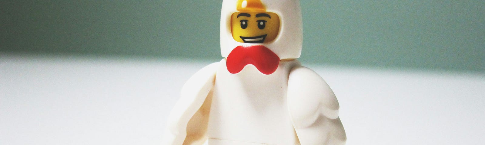 a plastic Lego man in a chicken suit