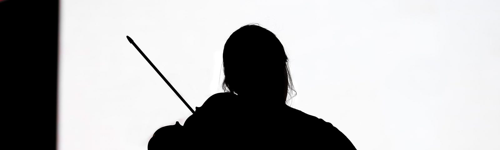 A sillouhette of a violinist playing toward a white screen