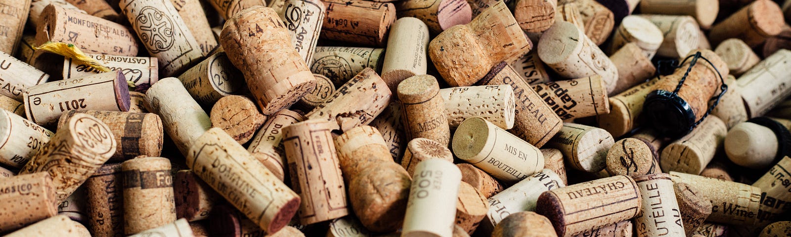 Corks from hundreds of different wine bottles lie discarded in a pile.