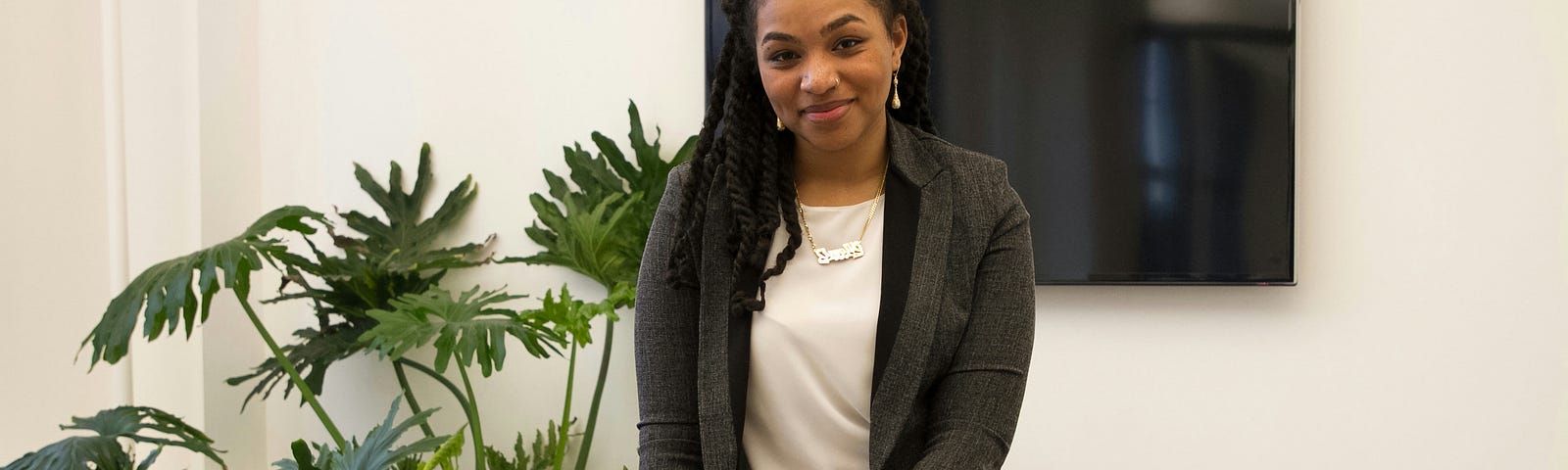 A woman smiling in an office environment, feeling grateful for her employment.